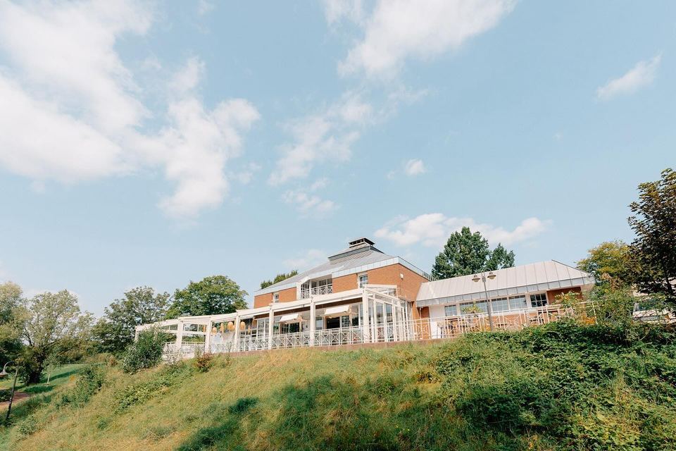 Deichgraf seen from the grassy slope, with the terrace and conservatory on top of the bank